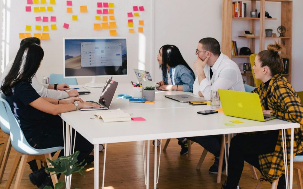 five person by table watching turned on white iMac